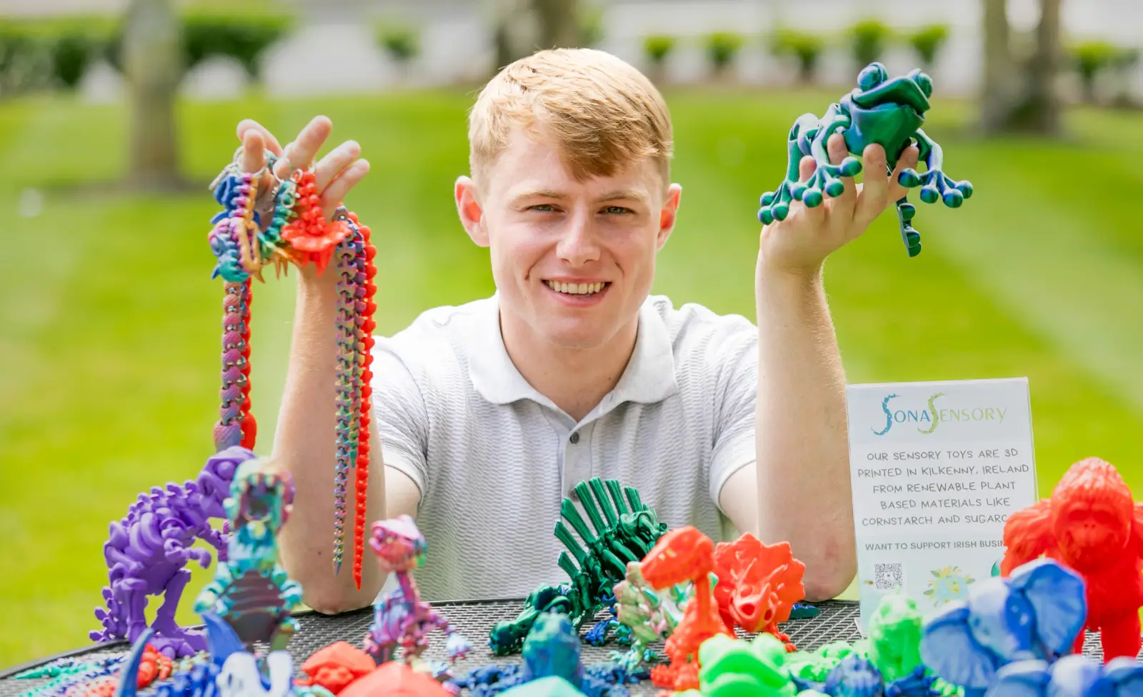 Young man showcasing 3D-printed Sona Sensory toys made from renewable materials.