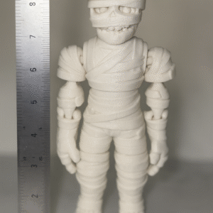 Boo Buddy Mummi: White 3D printed mummy action figure with bandaged body, skull face, and articulated joints. Collectible toy.