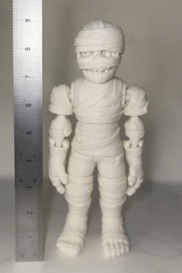 Boo Buddy Mummi: White 3D printed mummy action figure with bandaged body, skull face, and articulated joints. Collectible toy.