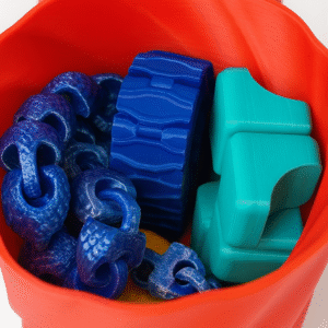 Fidget Sensory Bundle: Hand-sized blue chain links, blue gear, and teal blocks in a red container.