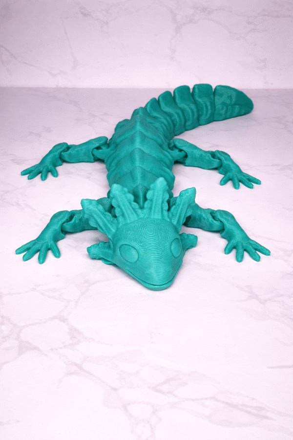 Teal 3D printed articulated Axolotl figure toy with movable joints on a white marble surface