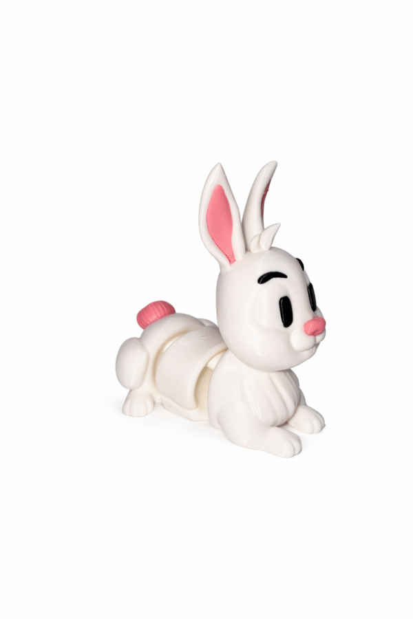 White plastic toy rabbit with pink accents, lying down.