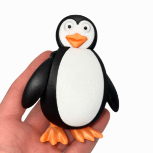 Penguin figure held in hand. 3D printed toy.