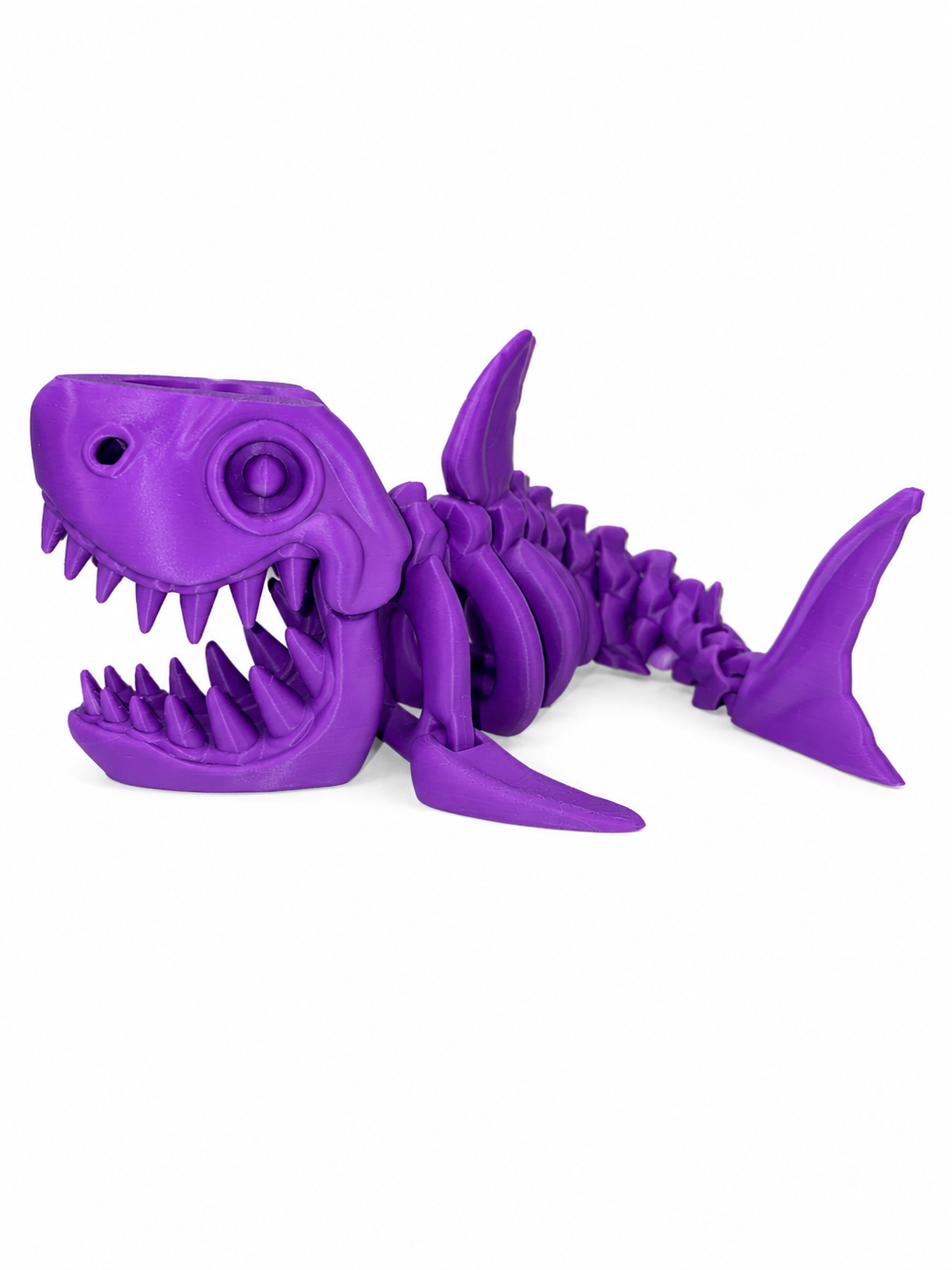 ChatGPT Image Jul 16 2026 12_04_24 PM Purple plastic toy shark with open mouth and sharp teeth lying on its side.