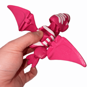 AUTO-DRAFT: Pink toy dinosaur skeleton with wings, held in hand.